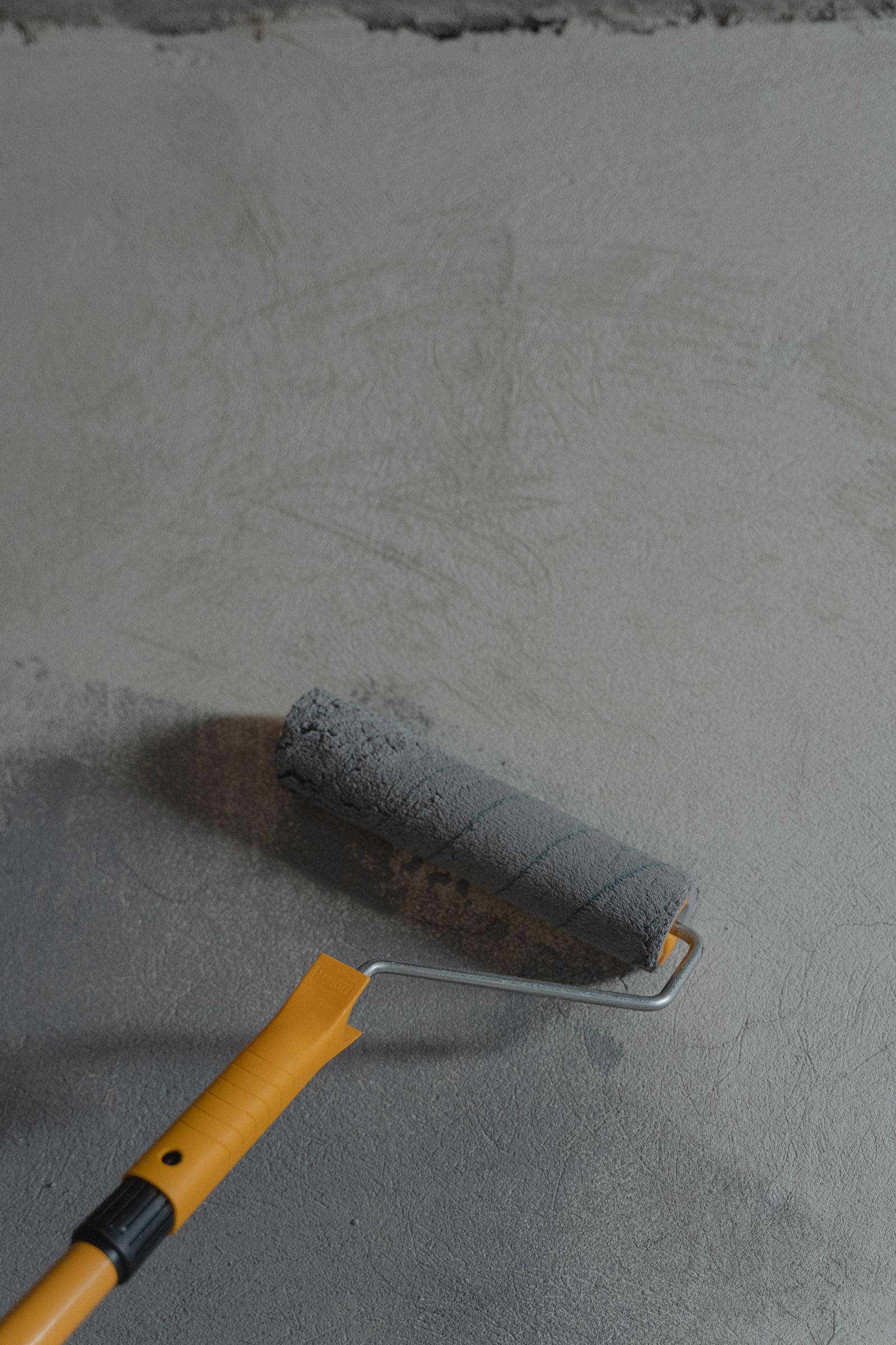 Detail nanášení šedé barvy válečkem